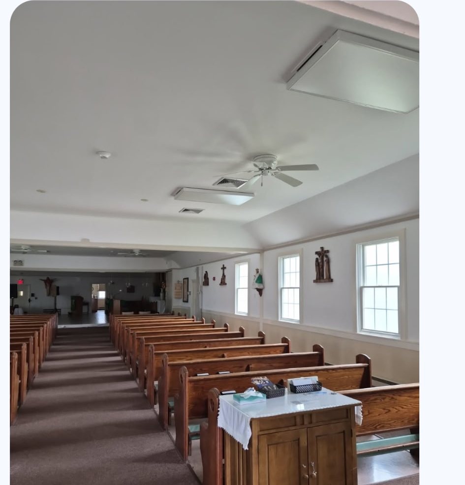 Church interior repainted in soft white with the pews and woodwork protected