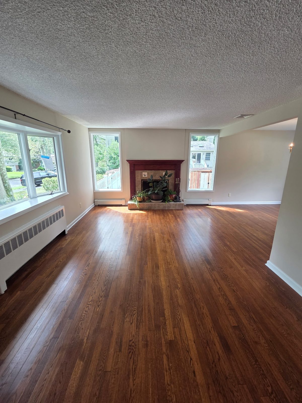 Living room with restored hardwood floor, fireplace and fresh white walls