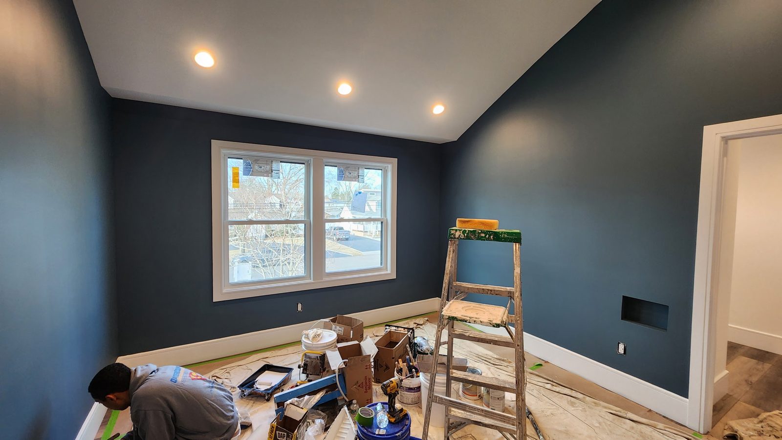A room mid-project with ladders, tins and drop cloths down