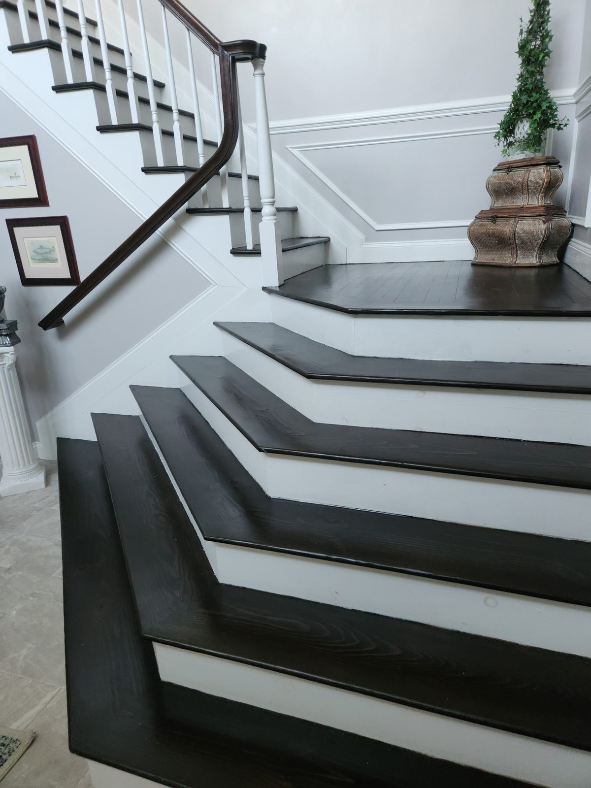 Staircase with black treads, white risers and panelled walls